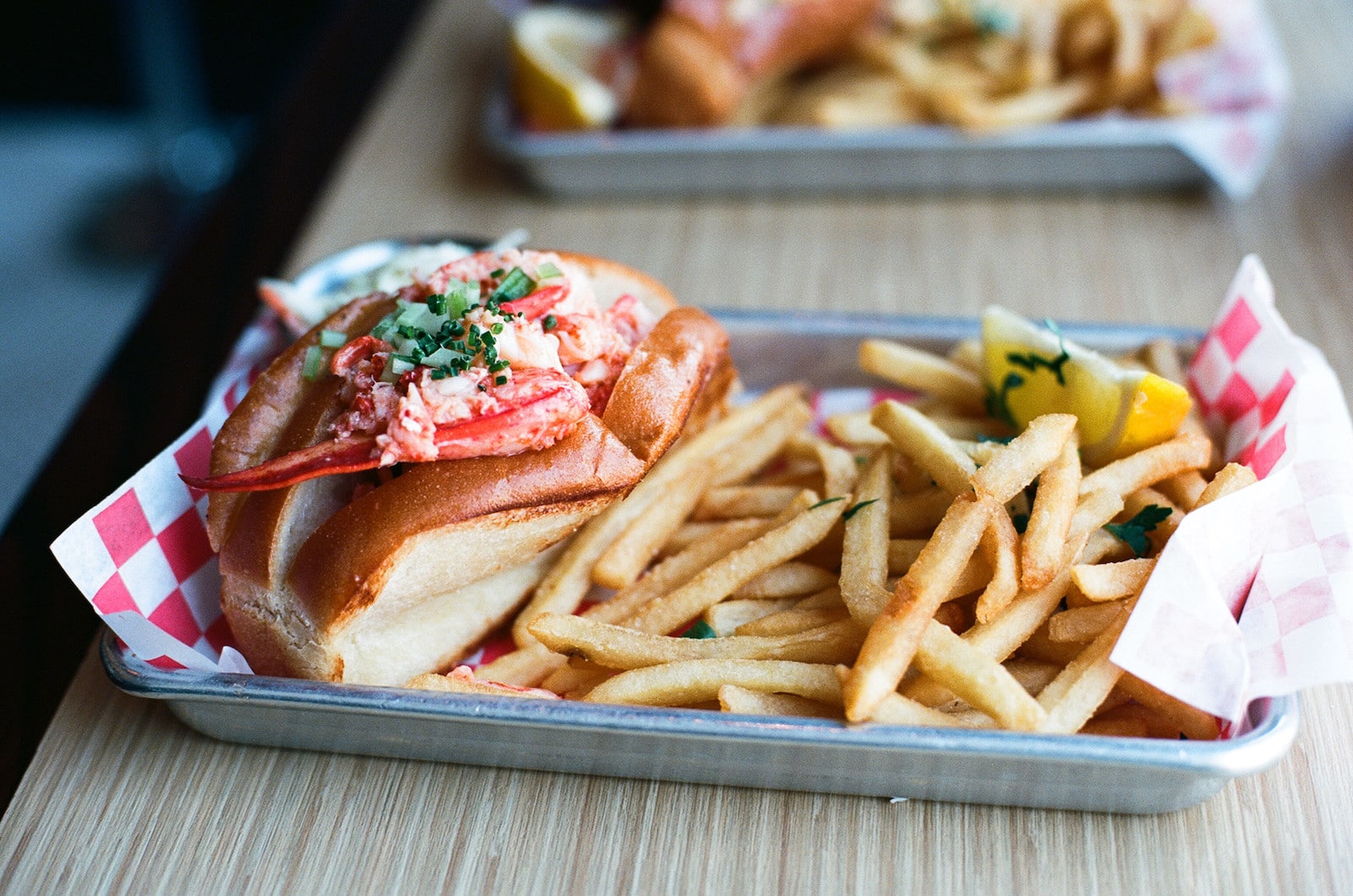 Image of a lobster roll with fries